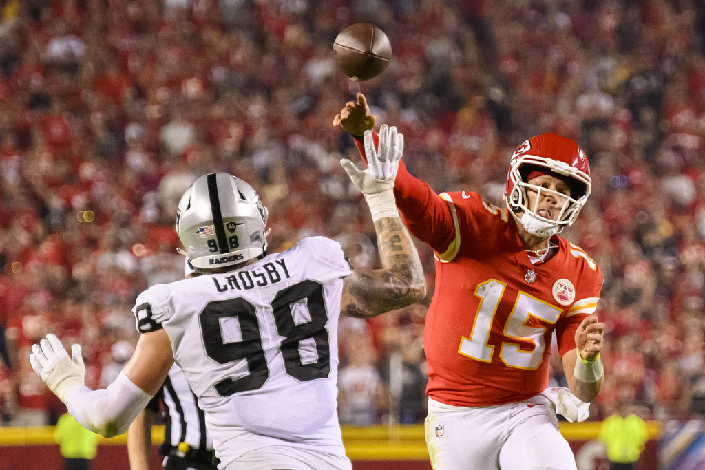 Quarterback Patrick Mahomes (R) of the Kansas City Chiefs is pressured by Las Vegas Raiders defensive end Maxx Crosby (#98) during the game at Arrowhead Stadium in Kansas City, U.S., October 10, 2022. /CFP 