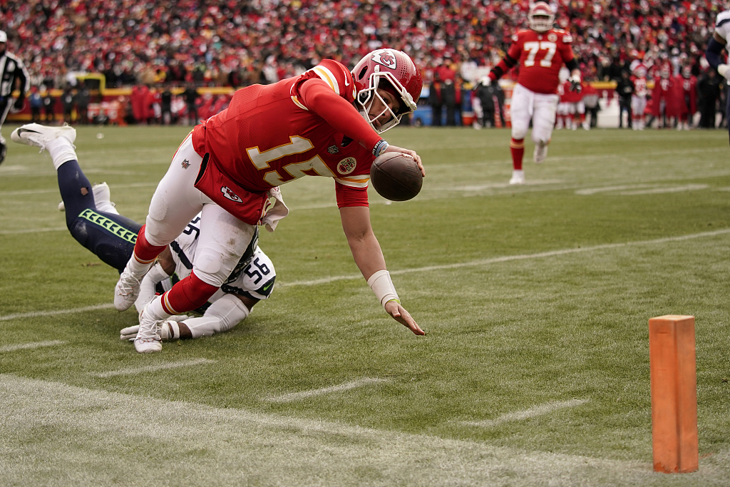 Quarterback Patrick Mahomes (#15) of the Kansas City Chiefs dives for the end zone pylon to score a touchdown as Seattle Seahawks linebacker Jordyn Brooks (56) defends during the game at Arrowhead Stadium in Kansas City, U.S., December 24, 2022. /CFP 
