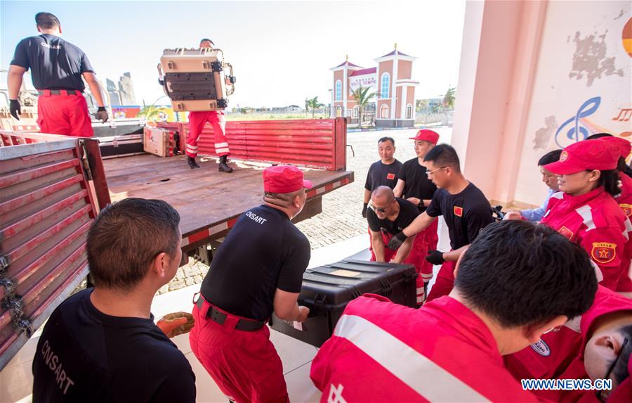 Chinese rescue team members carry the newly-arrived equipment and materials at a temporary station in Beira, Mozambique, on March 25, 2019. /Xinhua 