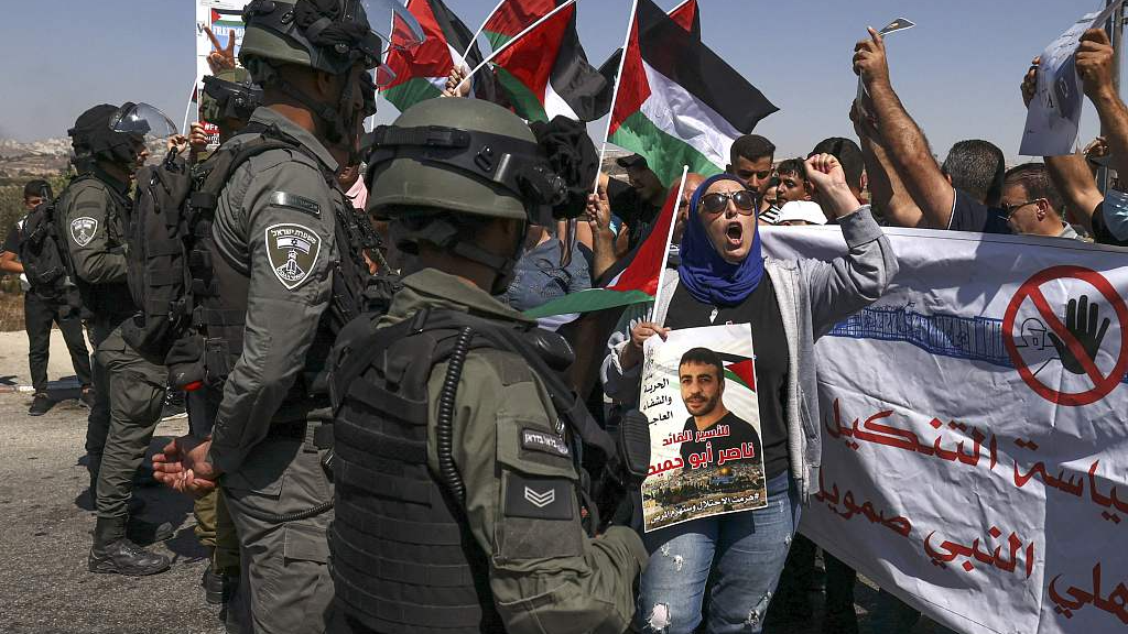Activists raise Palestinian national flags as they demonstrate at an Israeli checkpoint near the West Bank city of Ramallah, demanding the release of Nasser Abu Hamid, a Palestinian prisoner held by Israel who suffers from cancer, September 16, 2022. /CFP