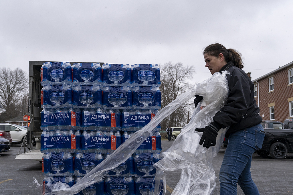 A volunteer distributes cases of water to residents in East Palestine, Ohio, February 17, 2023. /CFP