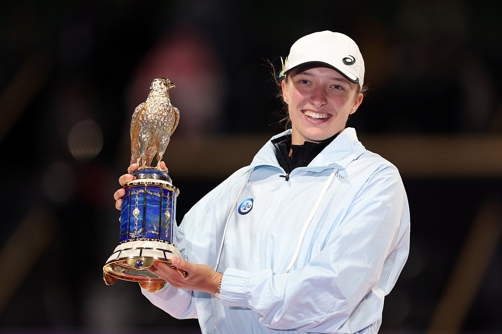 Polish tennis player Iga Swiatek celebrates with the trophy on the podium after defeating Jessica Pegula of the United States in the final at the Qatar Open in Doha, February 18, 2023. /CFP