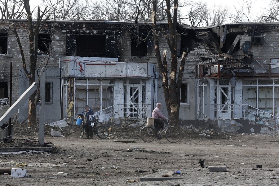 Residents are seen outside a damaged building in Volnovakha, one of the cities in the Donetsk region, Ukraine, March 15, 2022. /Xinhua
