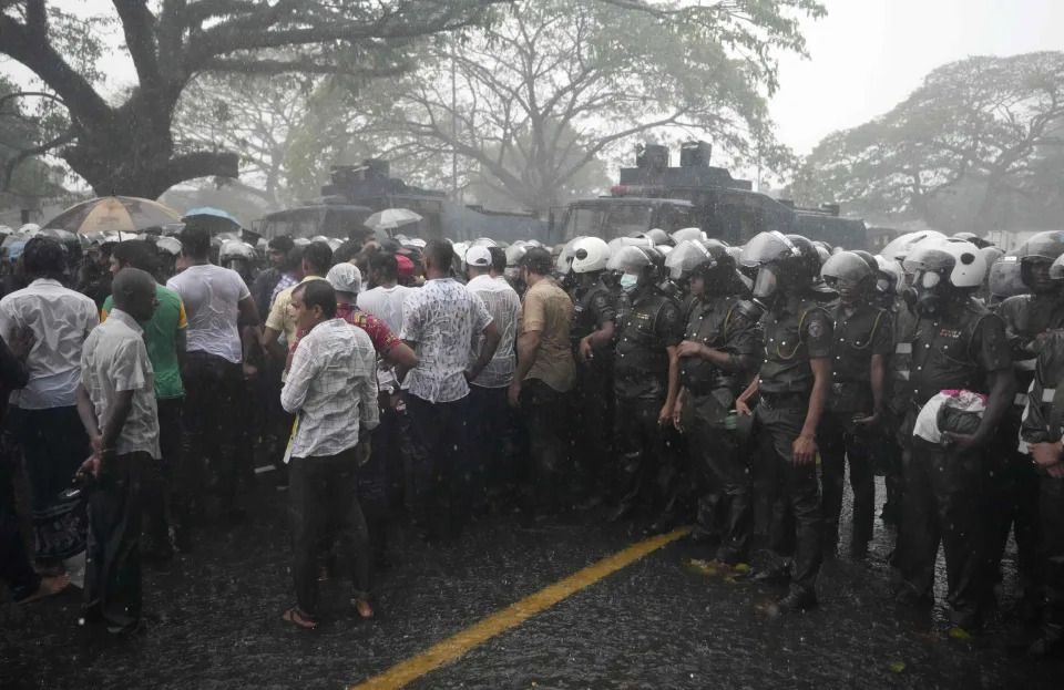 Supporters of Sri Lanka's main opposition stand in the rain after police stopped their march to protest against the postponement of local government election in Colombo, Sri Lanka, Feb. 20, 2023. /AP