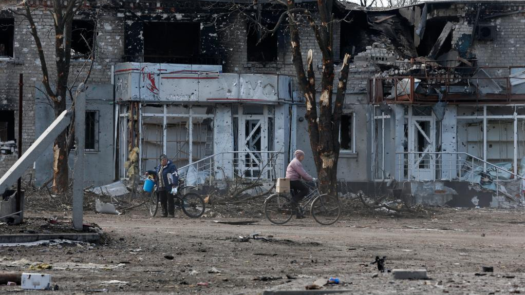 Local residents are seen outside a damaged building in Volnovakha of Donetsk, March 15, 2022. /CFP