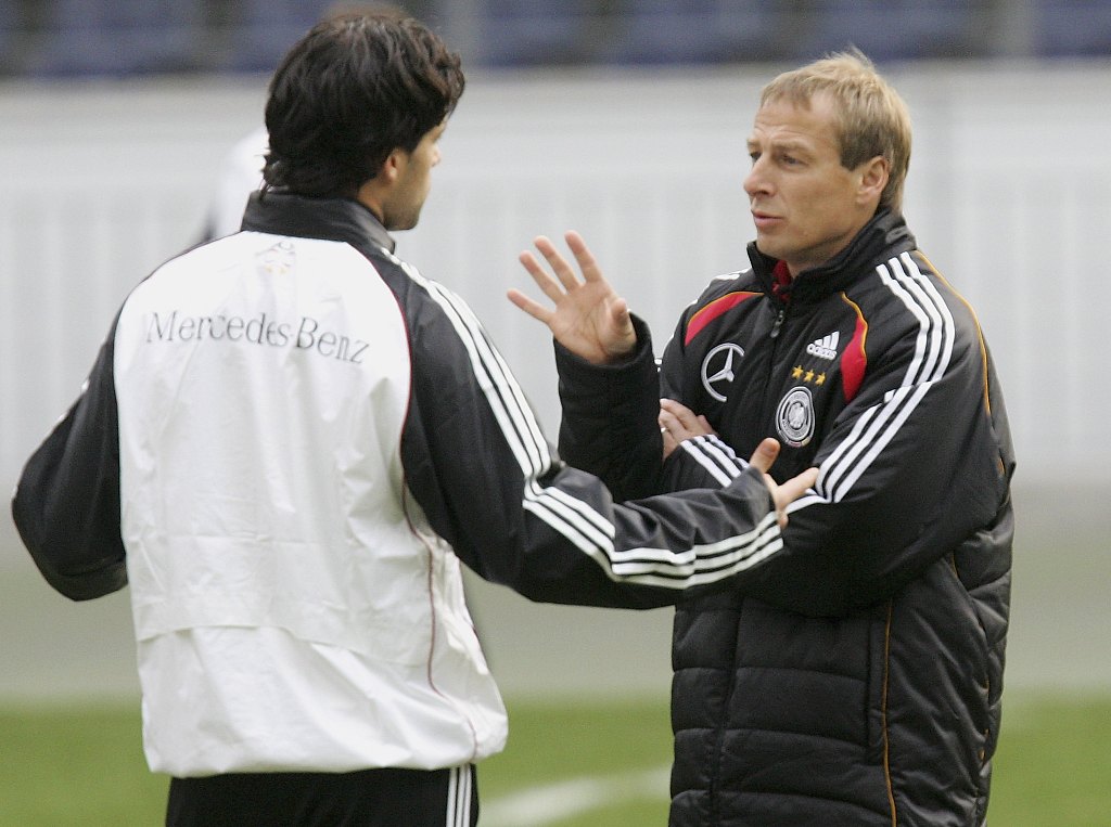 Jurgen Klinsmann (R), manager of Germany, talks to his captain Michael Ballack during the training session in Frankfurt, Germany, February 27, 2006. /CFP 