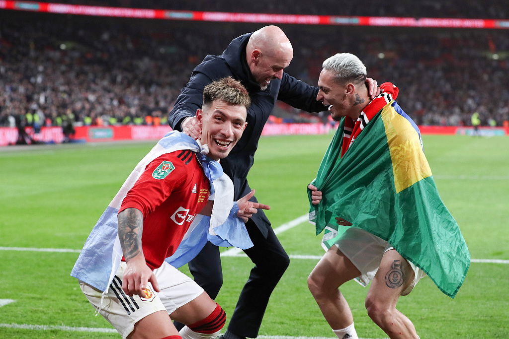 Manchester United manager Erik ten Hag (C) dances with Lisandro Martinez (L) and Antony after their League Cup win at Wembley Stadium, London, England, February 26, 2023. /CFP