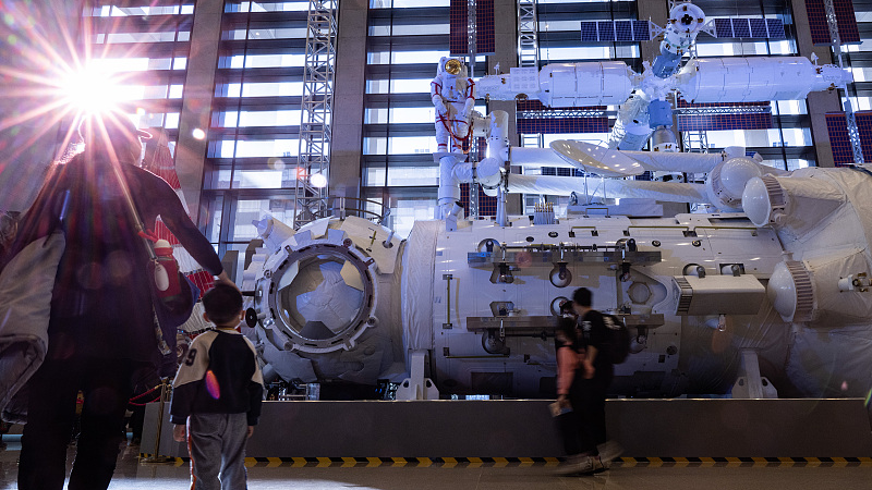 Visitors look at a 1:1 scale model of China Space Station's core module and a 1:4 scale model of the space station, February 24, 2023. /CFP