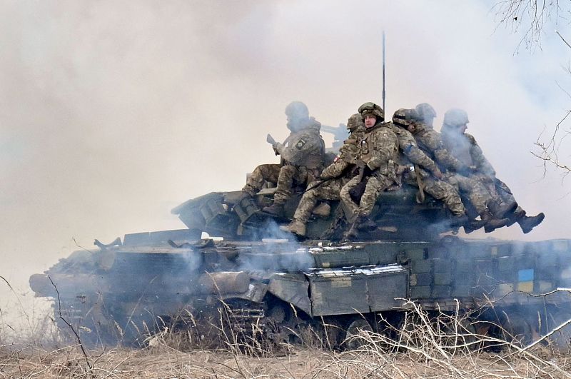 Ukrainian soldiers sit atop main battle tanks deploying smokescreens as they take part in military drills as they work out a possible attack in Chernobyl zone in few kilometers from the border with Belarus, February 20, 2023. /CFP