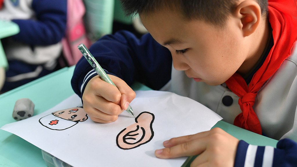 A primary school student draws a picture for National Ear Care Day, ‍Qingdao, east China's Shandong Province, March 3, 2023. /CFP