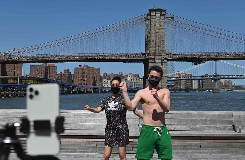 People dance and record themselves with a mobile phone for a TikTok video in front of the Brooklyn Bridge in New York City, May 26, 2020. /CFP
