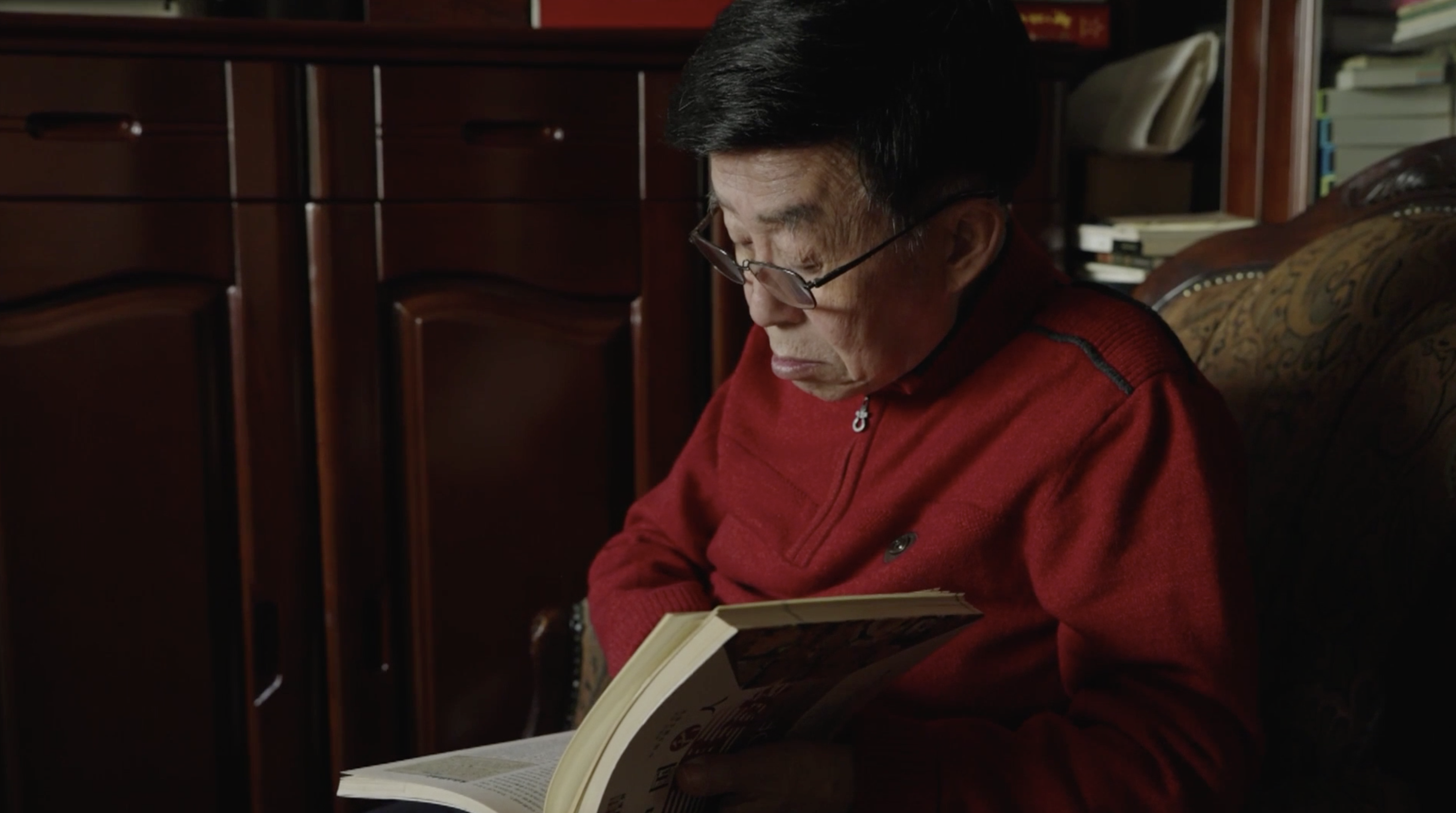 Tian Lianyuan consults materials for a 100-episode series on modern pingshu introducing the history of the Communist Party of China. /CGTN