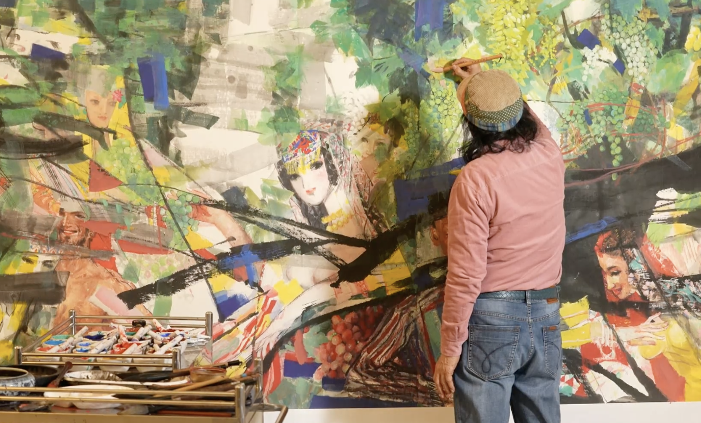Chinese painter Shi Qi labors on one of his artworks. /CGTN