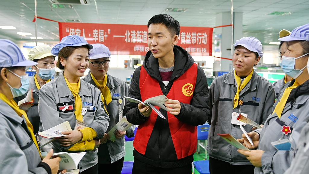 A volunteer tells female workers how to protect their legitimate rights and interests at a factory in Changzhou City, Jiangsu Province, east China, December 11, 2022. /CFP