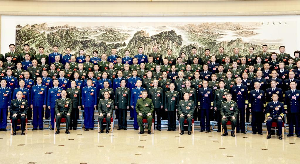 Chinese President Xi Jinping, also general secretary of the CPC Central Committee and chairman of the Central Military Commission, poses for a group photo with deputies from the delegation of the PLA and the People's Armed Police Force before  the plenary meeting of the delegation during the first session of the 14th NPC in Beijing, China, March 8, 2023. /Xinhua