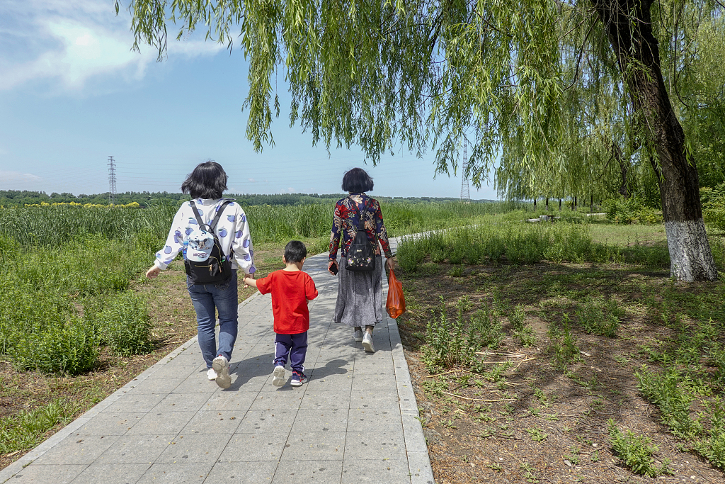 Visitors enjoy a leisurely stroll at Chaobai National Wetland Park. /CFP