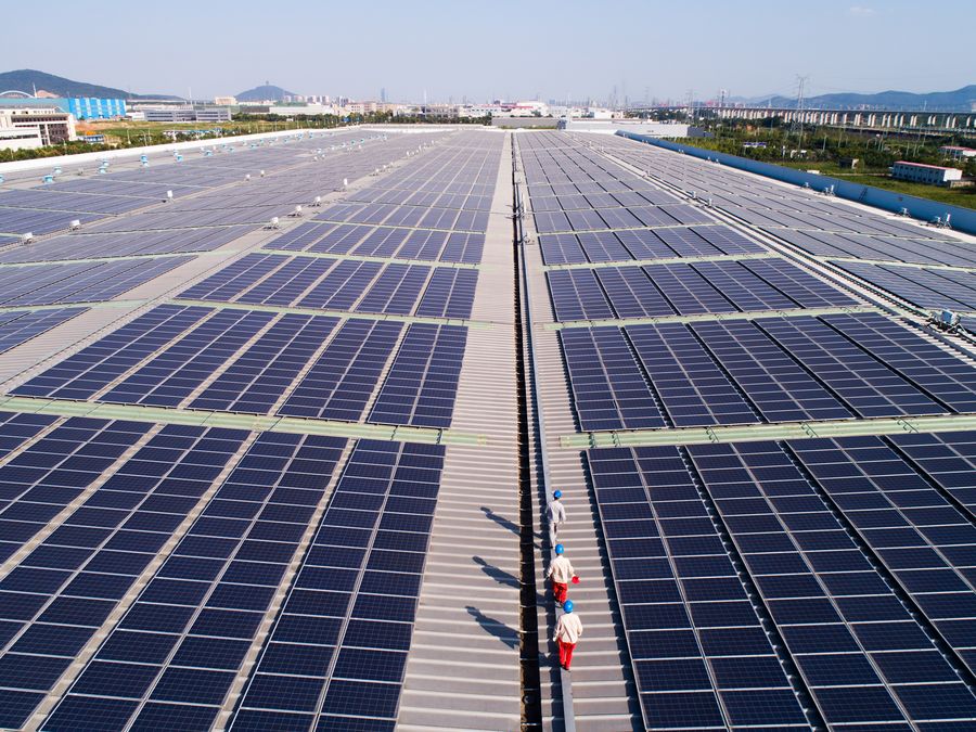 Workers examine solar panels on the rooftop of a local automobile maker in Huzhou, east China's Zhejiang Province, September 19, 2019. /Xinhua