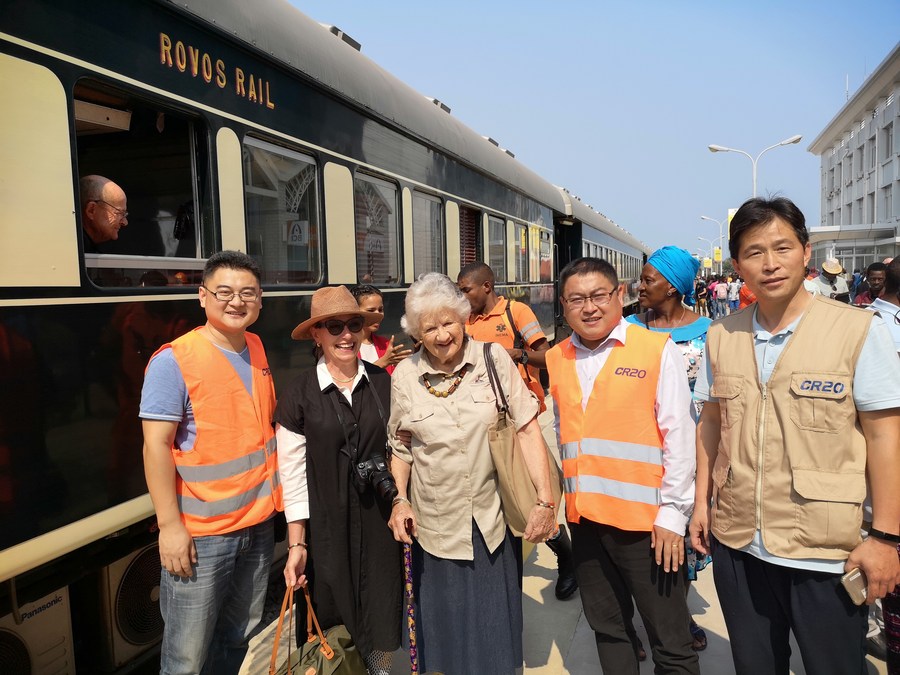 Staff of China Railway 20 Bureau who constructed the Benguela Railway pose for a group photo with visitors from Rovos Rail, in Lobito, Angola, July 30, 2019. /Xinhua