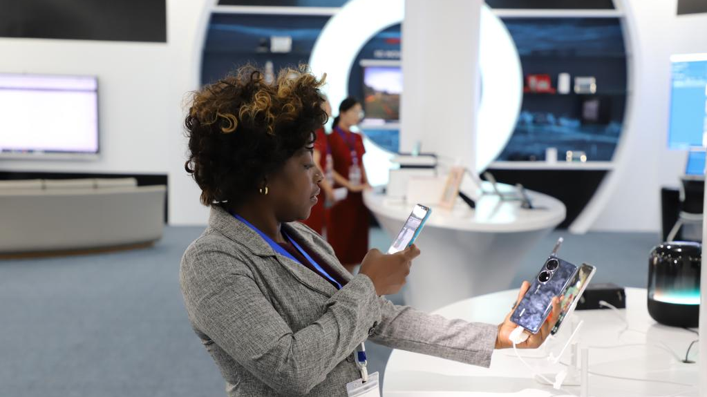 A visitor takes photos of a mobile phone displayed at the inauguration ceremony of Huawei's technology park, in Luanda, Angola, November 14, 2022. /Xinhua