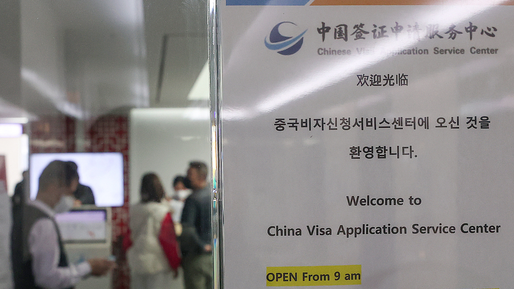 People wait in line at a Chinese visa service center in Seoul, South Korea, March 14, 2023. /CFP