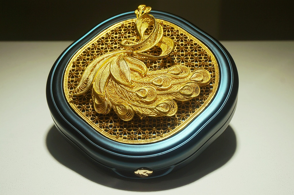 A powder compact case embossed with a filigree golden peacock is on sale at a makeup shop located beside the West Lake in Hangzhou, Zhejiang. /CFP