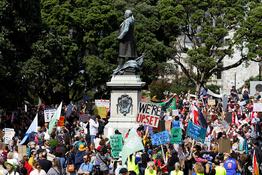 Teachers and supporters hold signs during a rally at Parliament in Wellington, New Zealand, March 16, 2023. /CFP