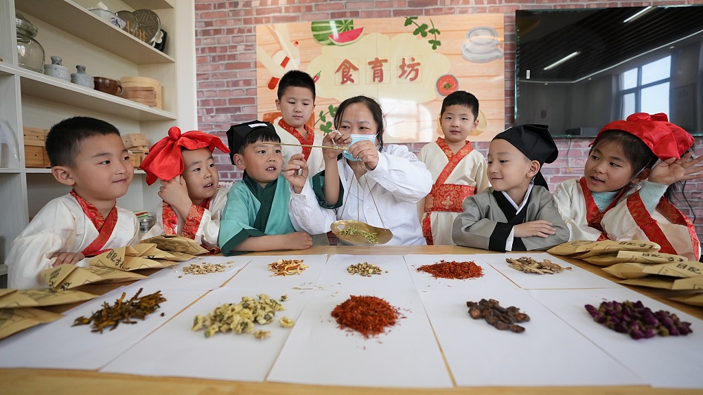 A pharmacist teaches children to recognize Chinese herbs at a kindergarten in Xingtai, Hebei Province. /CFP