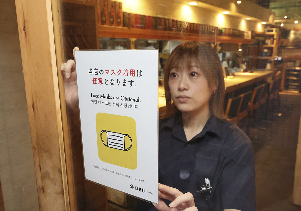 An employee displays a message that says face masks are optional at a restaurant in Fukuoka City, Fukuoka Prefecture, Japan, March 13, 2023. /CFP