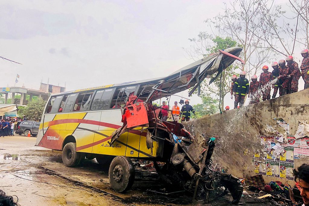 Firefighters extinguish a bus that had been in an accident in Madaripur, Bangladesh, March 19, 2023. /CFP