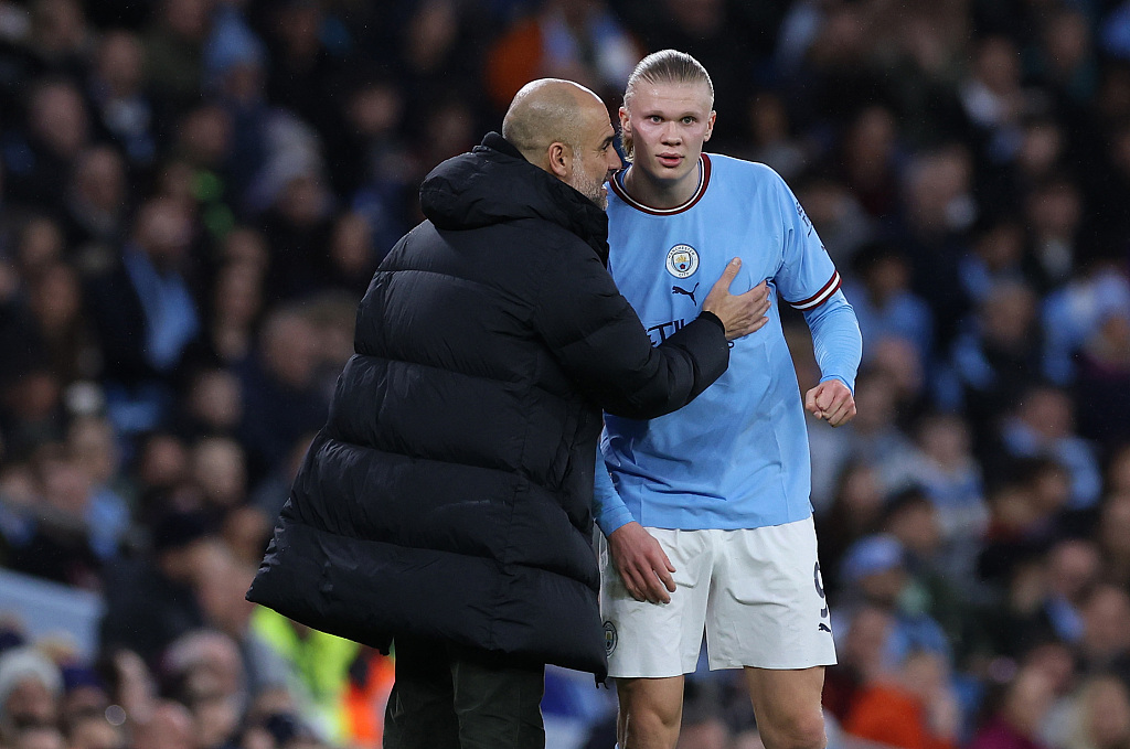 Manchester City manager Pep Guardiola (L) talks with Erling Haaland during their team's FA Cup clash with Burnley at Etihad Stadium in Manchester, England, March 18, 2023. /CFP