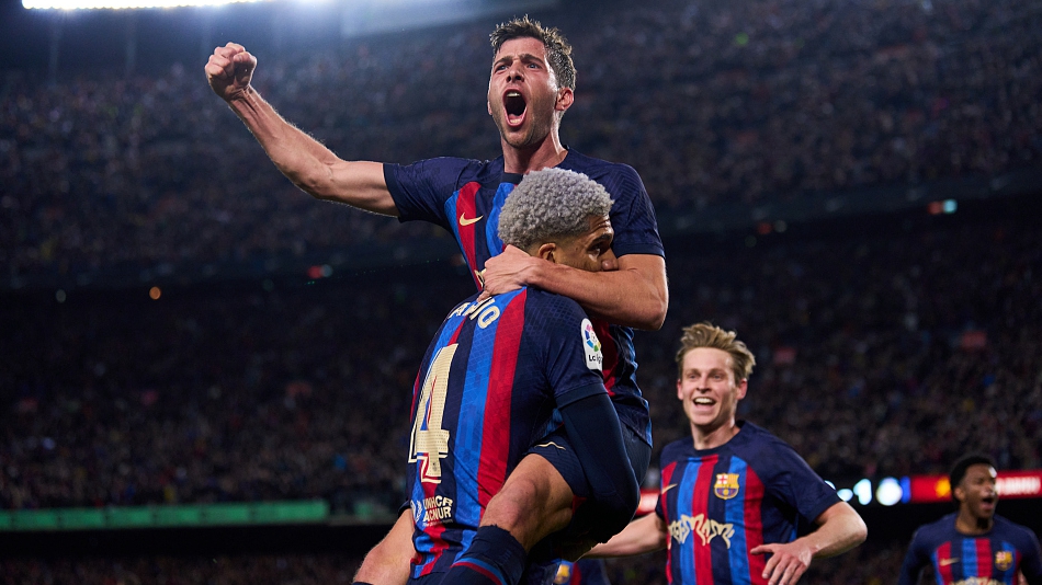 Sergi Roberto of Barcelona jumps into the embrace of his teammate Ronald Araujo during their clash with Real Madrid at Camp Nou in Barcelona, Spain, March 19, 2023. /CFP