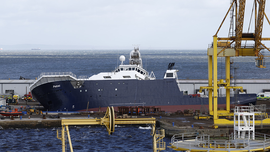 Emergency teams arrive at the scene after a ship tipped over at a 45-degree angle in the Imperial Dock area in Leith, Scotland, March 22, 2023. /CFP