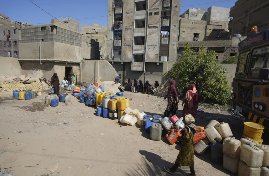 People wait to get drinking water from a water collecting point in a slum area, Karachi, Pakistan, March 21, 2023. /AP
