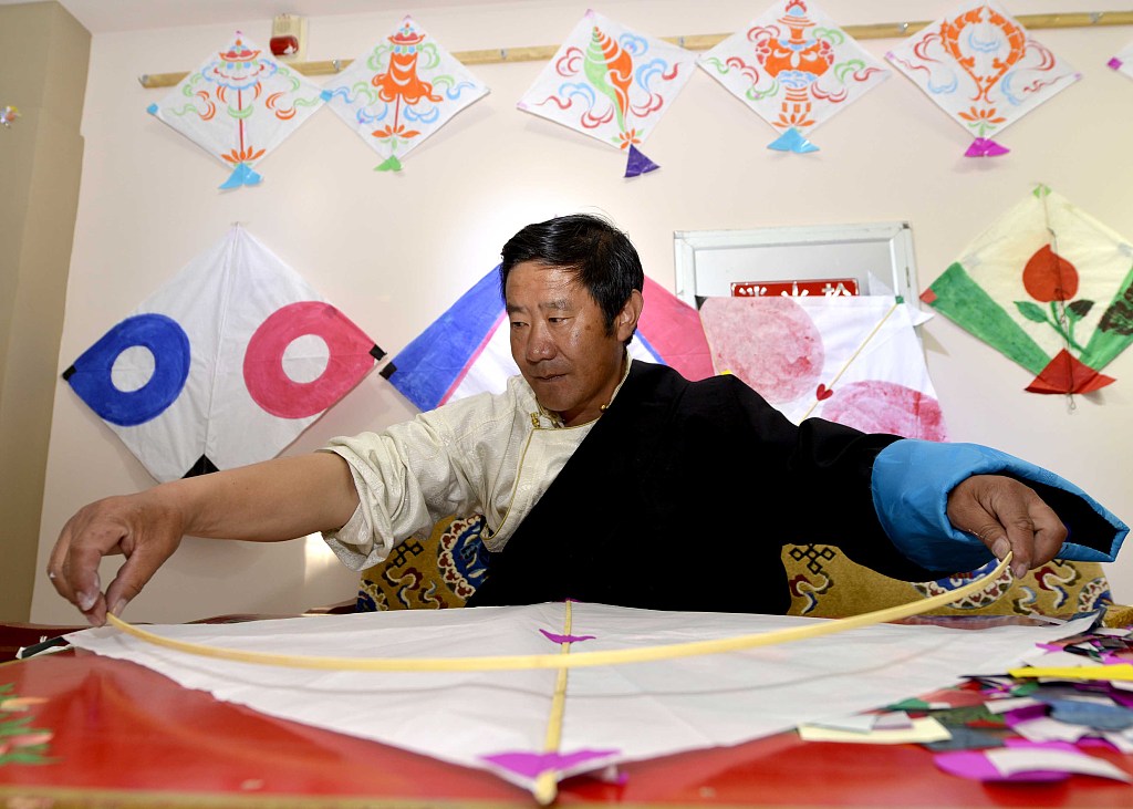 An intangible cultural heritage inheritor makes kites in Lhasa, Tibet. /CFP