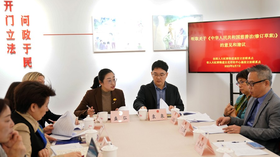 Sheng Hong (4th R), a deputy to the National People's Congress and Party chief of a residential community in the Hongqiao Subdistrict, listens to comments and suggestions of a draft revision to the Charity Law at a civic center in east China's Shanghai, February 7, 2023. /Xinhua