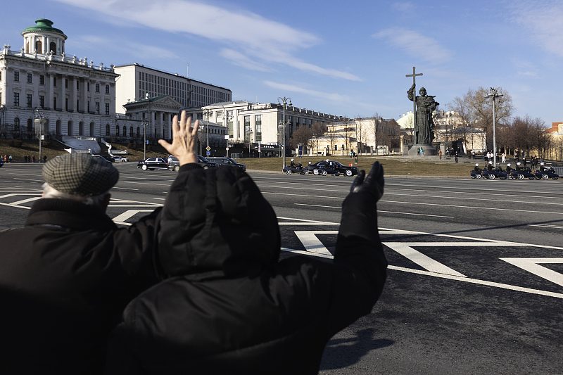 People wave to welcome Chinese President Xi Jinping's motorcade in Moscow, Russia, March 21, 2023. /CFP