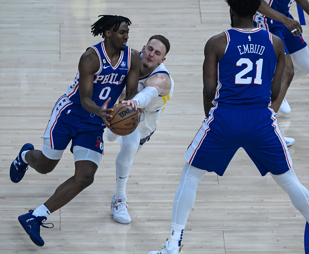 Donte DiVincenzo (C) of the Golden State Warriors tries to steal the ball from Tyrese Maxey (#0) of the Philadelphia 76ers in the game at the Chase Center in San Francisco, California, March 24, 2023. /CFP
