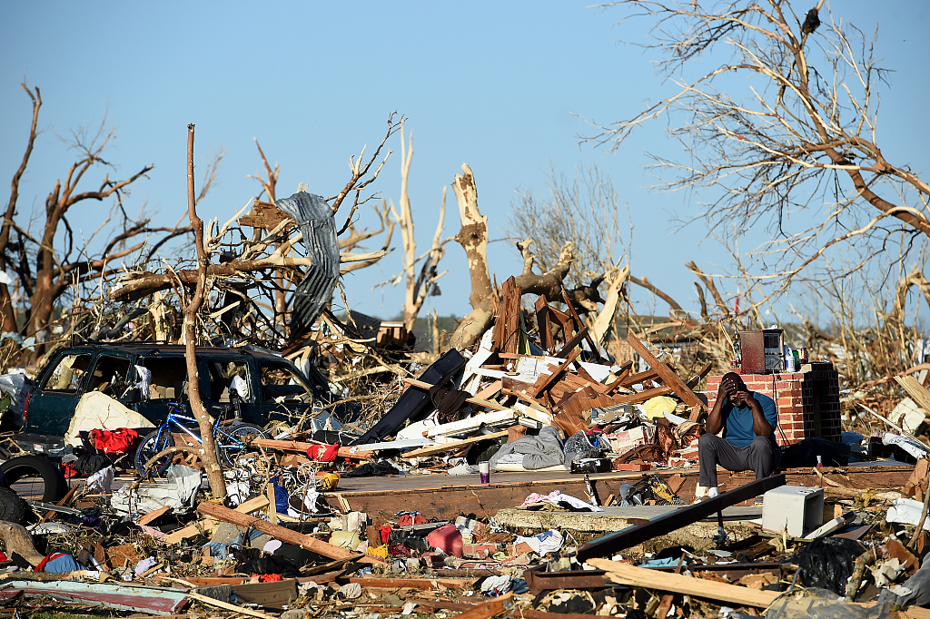A man sits amongst damage from a series of powerful storms and at least one tornado in Rolling Fork, Mississippi, March 25, 2023. /CFP