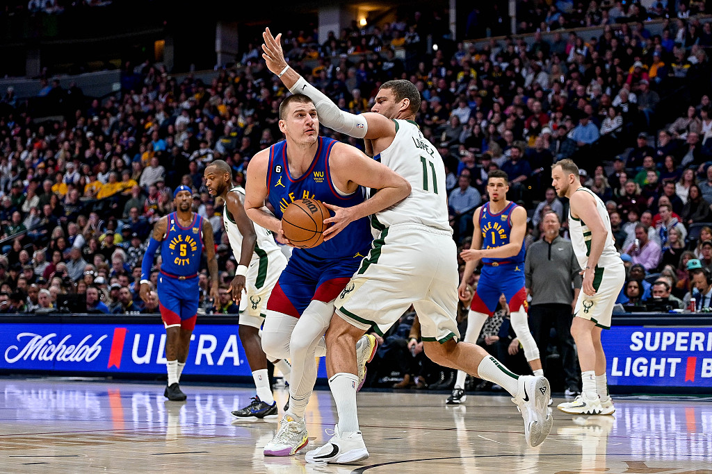 Nikola Jokic (L) of the Denver Nuggets spins to charge the rim in the game against the Milwaukee Bucks at Ball Arena in Denver, Colorado, March 25, 2023. /CFP