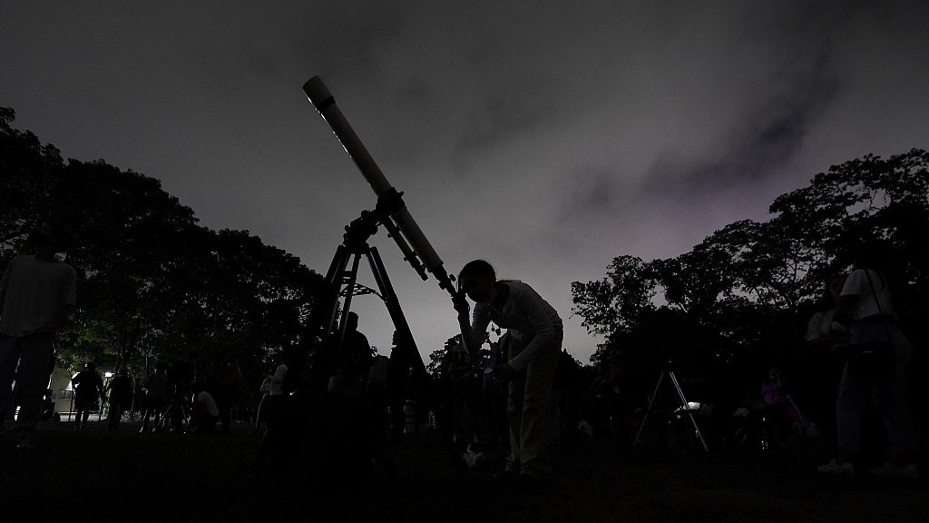 A girl looks at the moon through a telescope in Caracas, Venezuela, May 15, 2022. /CFP