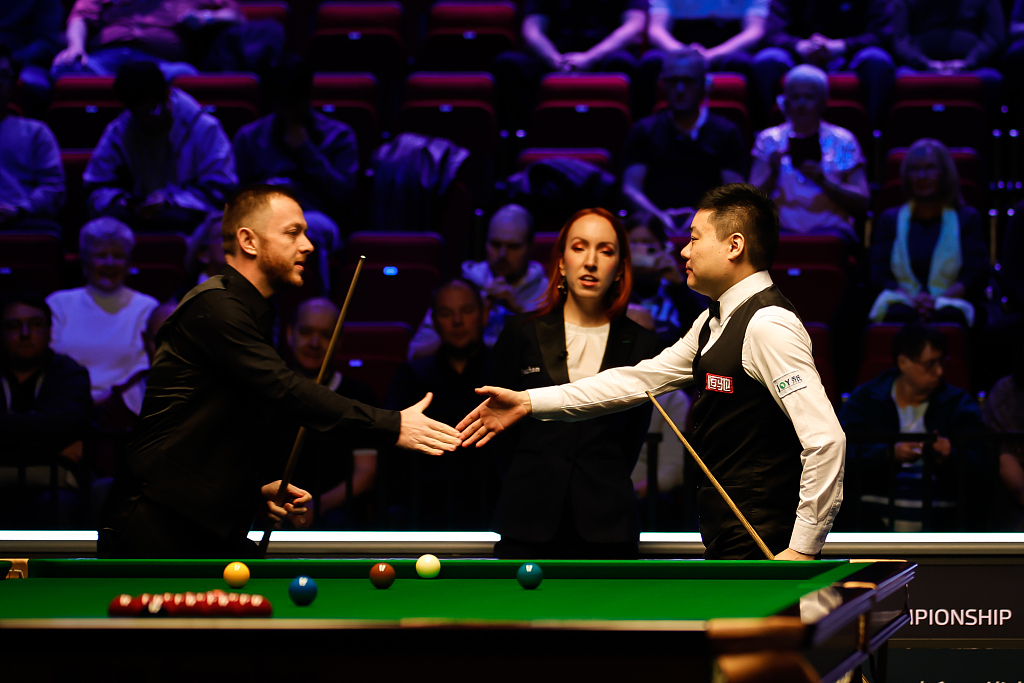 Ding Junhui (R) shakes hands with Mark Allen after the first round of the Tour Championship at Bonus Arena in Hull, England, March 27, 2023. /CFP