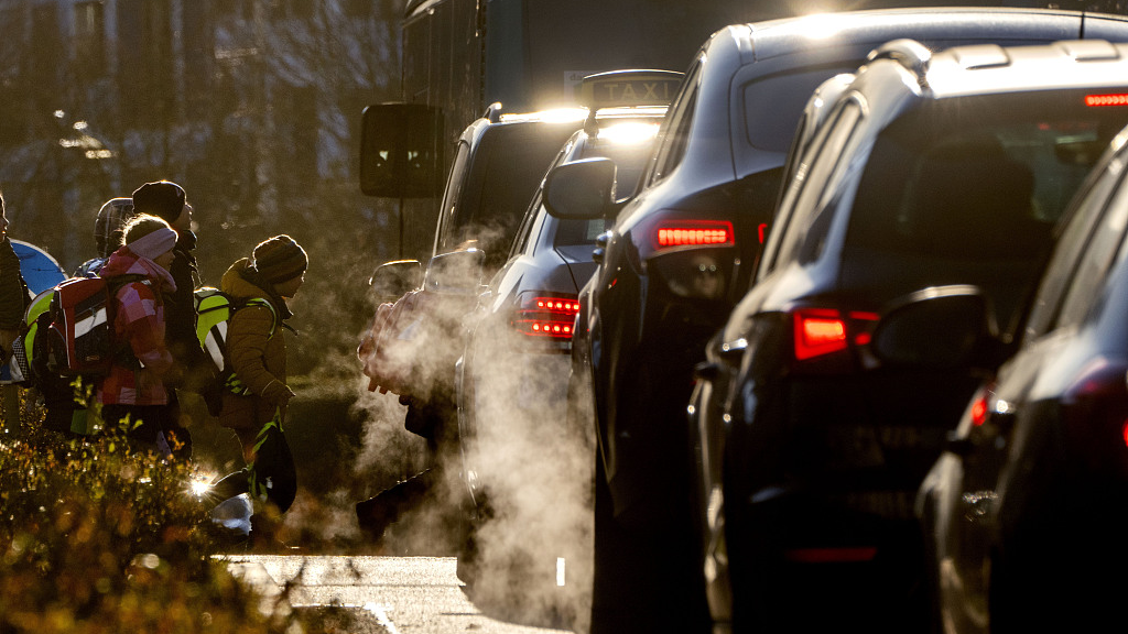 Cars give off exhaust fumes as children head to school in Frankfurt, Germany, February 27, 2023.