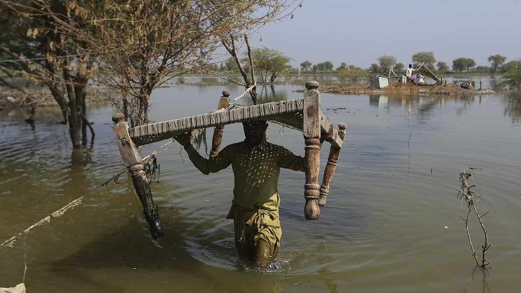 Villagers retrieve belongings, which they kept on higher grounds surrounded by floodwaters, at a village in Sohbat Pur, a flood-hit district of Baluchistan province, Pakistan, Oct. 25, 2022. /CFP