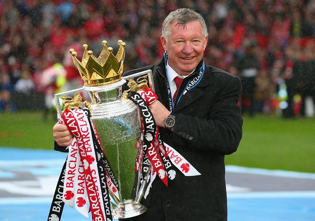 Sir Alex Ferguson celebrates with the Premier League trophy following the match between Manchester United and Swansea City at Old Trafford in Manchester, England, May 12, 2013. /CFP