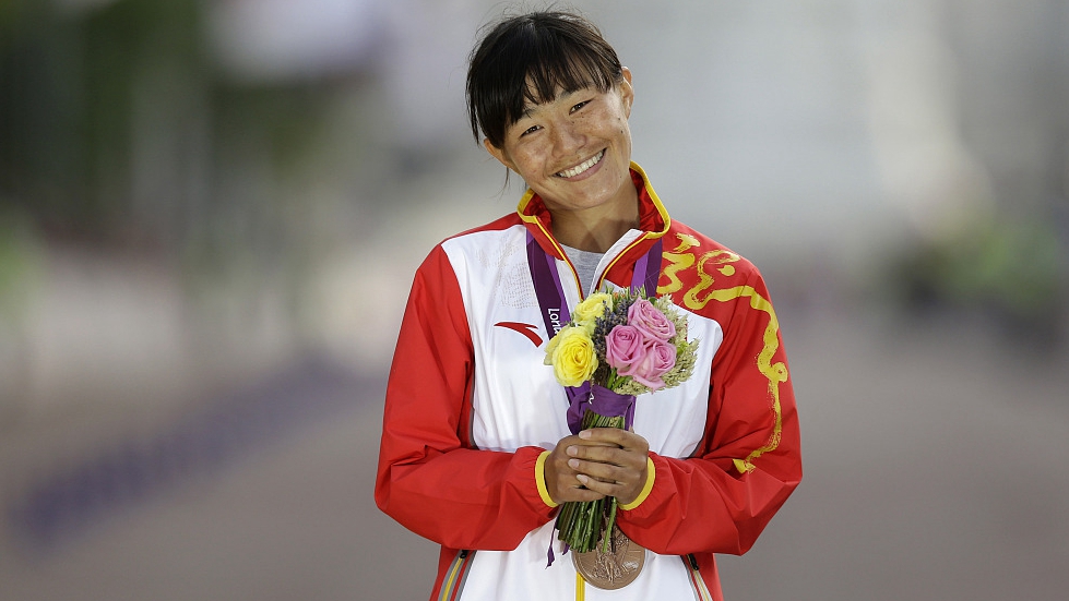 China's Qieyang Shijie poses for photographers after winning the bronze medal in the women's 20km race walk at the Olympics in London, England, August 11, 2012. /CFP