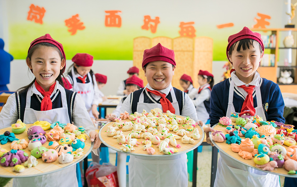 Students from a primary school in Hohhot, Inner Mongolia show their culinary prowess at making 