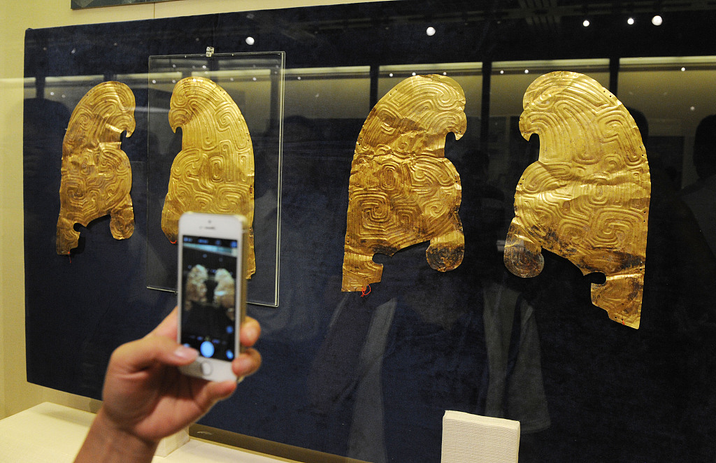 A visitor takes a snap of some gold ornaments that French collectors handed over to China at the Gansu Provincial Museum in the country's northwestern region on July 20, 2015. /CFP