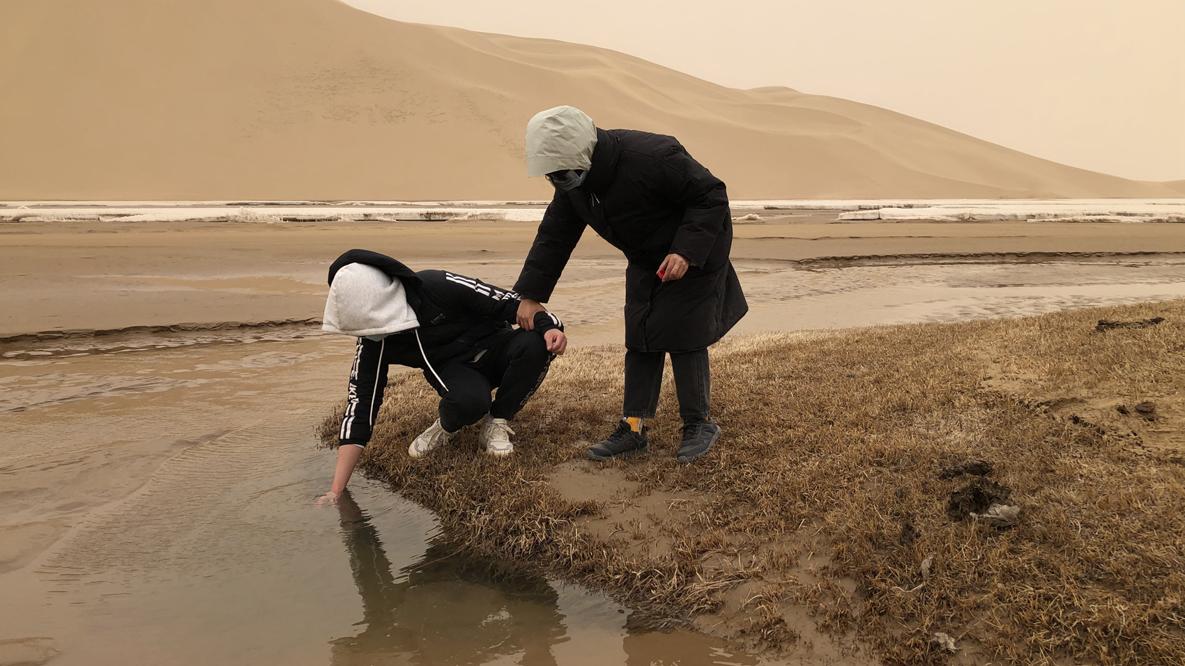 Collecting water sample from the upstream of a river in the Arjin Mountains, April 3, 2023. /Sun Zifa