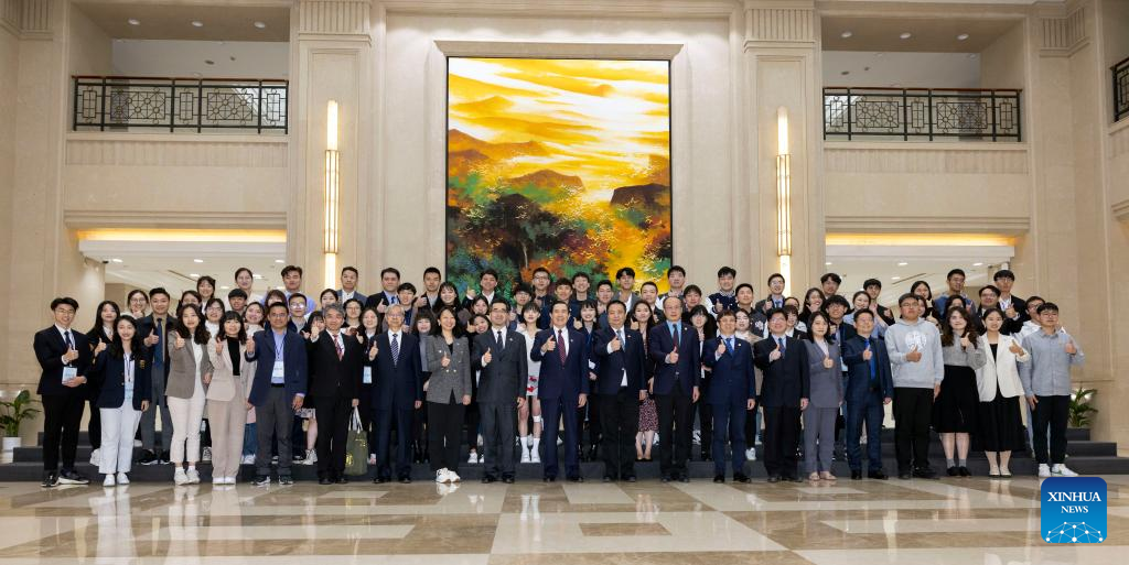 Ma Ying-jeou poses for a photo with faculty members and students from Fudan University after a group discussion at Fudan University, April 6, 2023. /Xinhua