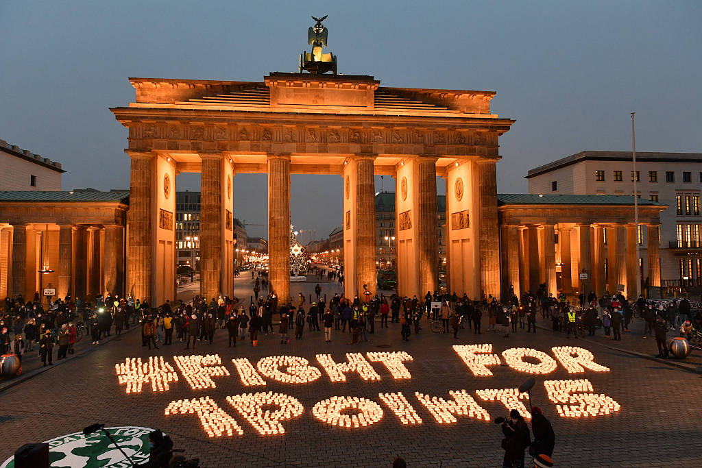 Climate strikers light candles in front of the Brandenburg Gate in Berlin, Germany, December 11, 2020, marking the fifth anniversary of the Paris Agreement. /CFP